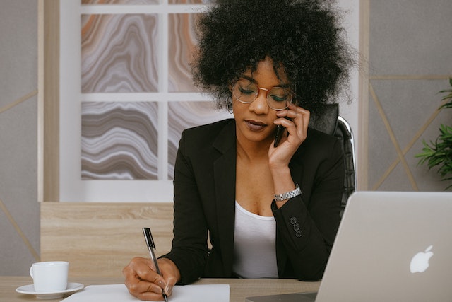 business woman on phone and taking notes